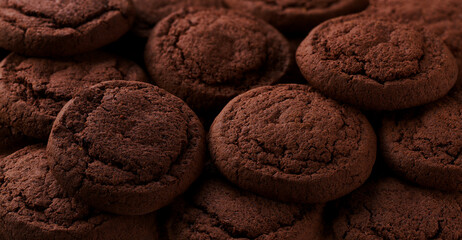 Chocolate cookies placed throughout the screen selective focus. Food background.