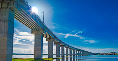 Fototapeta premium Modern Concrete Bridge Over Tranquil River with Blue Sky