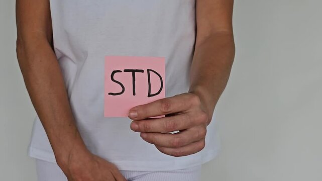 Woman showing STD sign and holding genitals