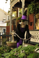 Skeleton in pointy hat on a bicycle, witchlike