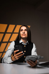 Woman holding a stack of dollars while working on a laptop. Accountant works with money. Concept of working in a bank. Credits and loans. Counting cash.Earnings online