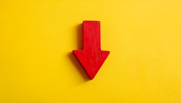 Red wooden arrow pointing down on yellow background. Business, market decline or economic