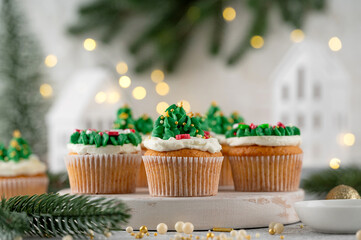 Christmas tree and wreath shaped cupcakes with candy sprinkles on top. Christmas dessert on a light concrete background.