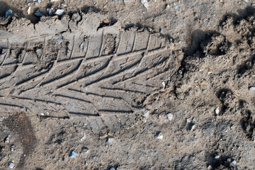 Tire Track Imprint on Muddy Ground
