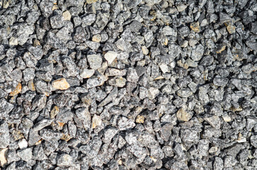 Abstract background of small stones. Gray crushed stone , scattered in an embankment. Landscape design.