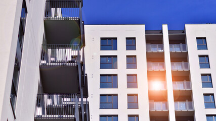 Modern high-rise apartment building  in white, stand tall against a blue sky, exemplifying...