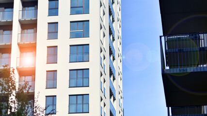 Modern high-rise apartment building  in white, stand tall against a blue sky, exemplifying innovative urban architecture with sleek, angular designs.