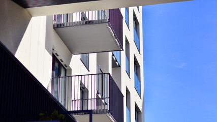 Modern high-rise apartment building  in white, stand tall against a blue sky, exemplifying...