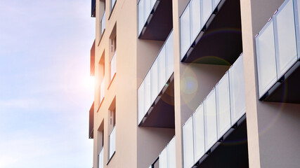 Modern high-rise apartment building  in white, stand tall against a blue sky, exemplifying...