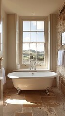 Bath, rustic countryside bathroom with freestanding, claw-foot bathtub by window overlooking rolling hills. Natural light and warm ambiance highlight stone walls and tiled floor.