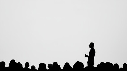 Speaker presenting to an audience silhouette against a blank background at a conference