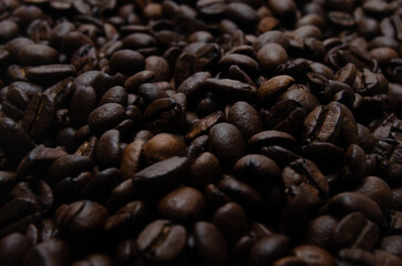 A pile of coffee beans. All stacked together, waiting to be ground into a delicious cup of coffee. A close-up shot of roasted coffee beans. Different types of delicious coffee beans.