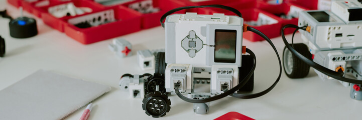 Website banner of tine robot with display and silicone buttons on desk top