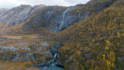 Waterfall Cascading Down Rocky Cliff in Autumn