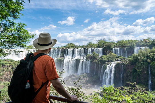 Hombre viajero, con sombrero y mochila, contemplando las vistas de las Cataratas del Iguaz&uacute;, en Argentina