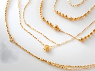 A close-up of a set of gold necklaces with various chain styles and pendants.