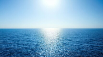 Obraz premium A bright, sunny day with clear blue skies and calm, blue ocean water reflecting the light.