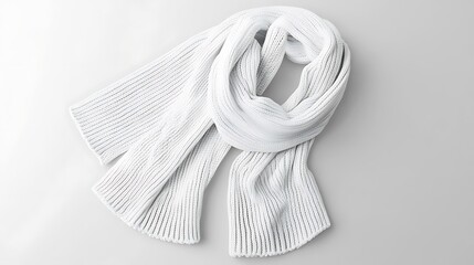 A white knitted scarf lies on a white surface.