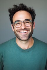 A man with glasses and a green shirt smiling