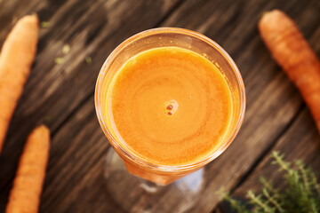 A glass of fresh carrot juice on a table