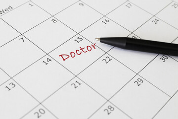 Blue circle marked with pen and writing Doctor on calendar.	

