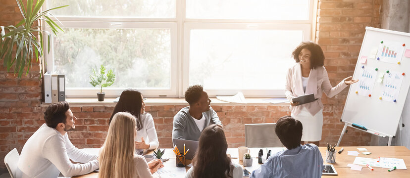 Black lady employee making presentation during morning briefing in office
