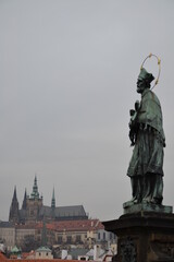 Fototapeta premium Sculpture d’un Saint du pant Charles, et du Château de Prague