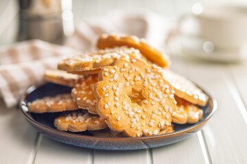 Sweet cookies in the shape of a flower. Tasty biscuits on plate on white table.