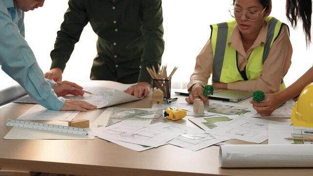 Professional engineer measuring the blueprint. Professional engineer working architectural project at studio on a table with yellow helmet and architectural equipment scatter around. Delineation.