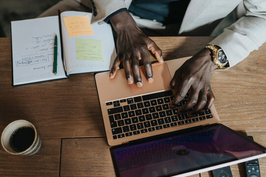 Hands of businessman typing on laptop at desk