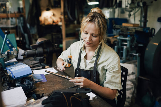 Female craftsperson making jewelry at workshop