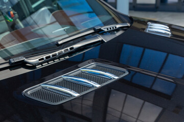 Close-up of chrome-plated air intakes on the hood of a black car