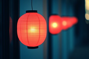 Fototapeta premium Red lantern hanging from wall, casting warm glow, creating cozy, inviting ambiance in dimly lit space.