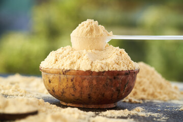 Whey protein powder in a measuring scoop and a bowl
