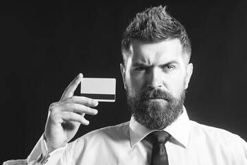 Serious bearded businessman, banker showing credit, debit or payment card. Online shopping, cashless payment. Banking service. Bank card design mockup with magnetic stripe. Copy space for advertising.
