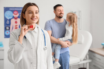 Female endocrinologist with thyroid gland model in clinic