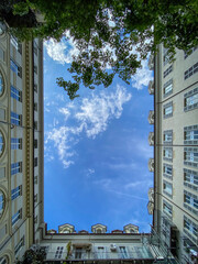 Low angle view of courtyard of a building in the center of Turin, Italy against blue sky with clouds