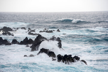 Waves braking on rocks in a stormy weather at sea