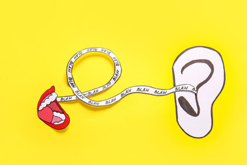 Paper mouth with words BLAH and ear on yellow background. Gossip concept