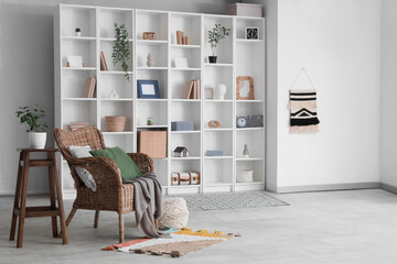 Interior of stylish modern living room with armchair and big shelving unit
