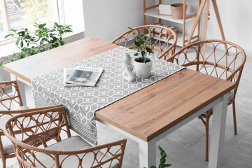 Stylish table with chairs and houseplants in kitchen