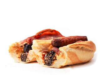 Traditional Irish breakfast roll with cooked sausages, bacon or rashers and black and white pudding in a round bread on light color paper. Popular meal with high calorie count.