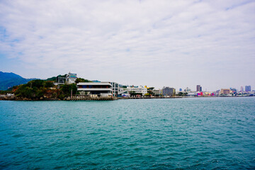 Fototapeta premium Kaohsiung, Taiwan, Republic of China, 01 25 2024: The landscape of Kaosiung port harbor, downtown, shiziwan (siziwan, xiziwan), and shoushan mountain seen from Qijin lighthouse