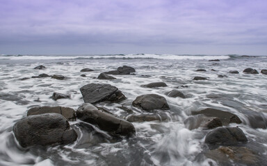 Obraz premium Ocean landscape of foamy sea water running over rocks