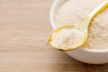 Organic gelatin powder also called hydrolyzed collagen - White powder in the bowl and spoon