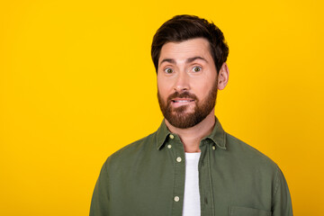 Portrait of nice young man bite lips think wear khaki shirt isolated on yellow color background