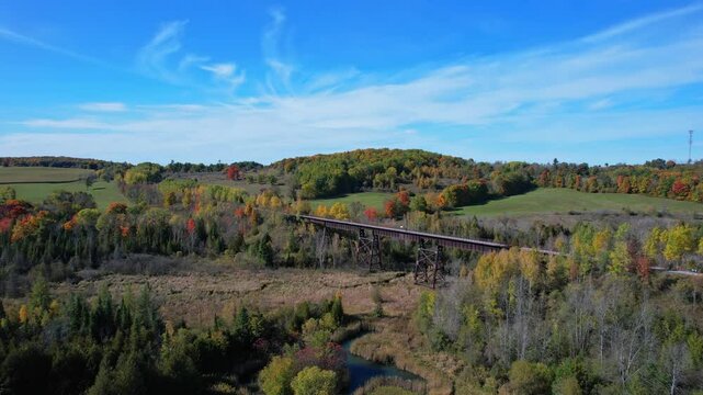 Doube's Trestle Bridge historical landmark, Trans-Canada Trail, Kawartha Lakes in Ontario, Canada. Picturesque aerial view of Autumn Canadian Forests and nature. Orange red and yellow trees at fall.
