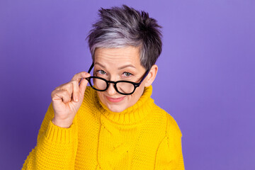 Fototapeta premium Stylish mature woman with glasses in yellow sweater on purple background
