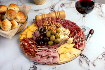 cold cuts table with assorted cheeses, Sardinian provolone and flavoured with oregano and olives, homemade bread with loin, ham, pork shoulder, bacon, salami, mortadella with nuts and a variety of col