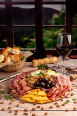 cold cuts table with assorted cheeses, Sardinian provolone and flavoured with oregano and olives, homemade bread with loin, ham, pork shoulder, bacon, salami, mortadella with nuts and a variety of col